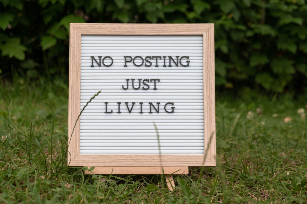Letter Board With Text NO POSTING JUST LIVING In Grass Green Background. Concept Of Digital Detox, Unplugging From Technology Break. Mindful Living