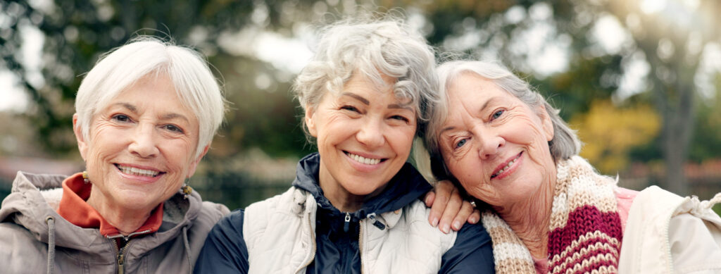Senior, Women And Friends Face In Park With Bonding And Retirement Smile In A Garden. Nature, Portrait And Hug With Elderly Female People On Vacation In Woods Feeling Happy From Bonding And Freedom