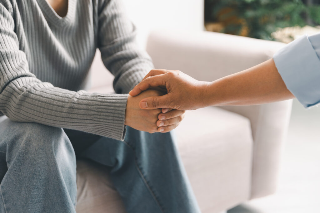 Close Up Of Professional Counselor Holding Patient's Hand To Provide Comfort And Empathy During A Mental Health Therapy Session. Supportive Gesture For Depression Recovery And Emotional Healing.