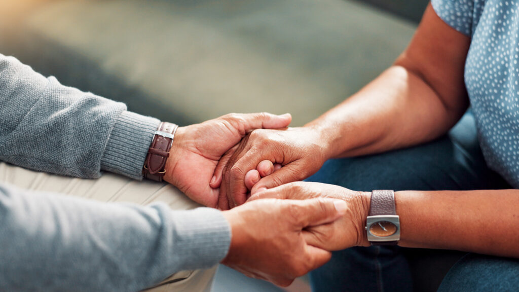 Comfort, Empathy And Holding Hands With Senior Couple In Home Living Room Together For Love Or Support. Compassion, Sympathy And Trust With Old People Closeup In Apartment For Connection Or Healing