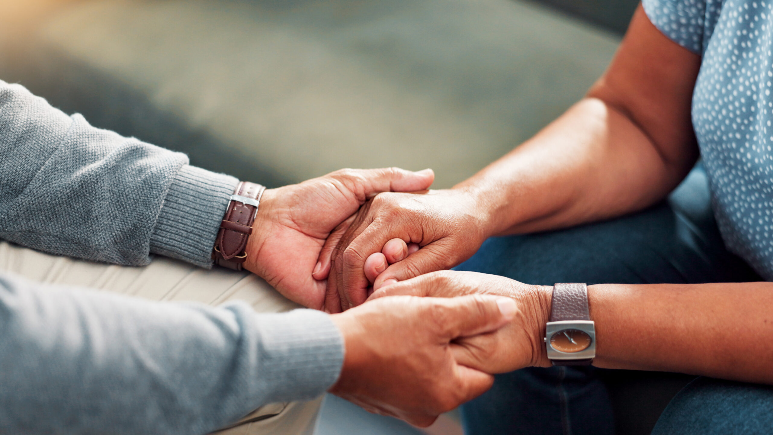 Comfort, Empathy And Holding Hands With Senior Couple In Home Living Room Together For Love Or Support. Compassion, Sympathy And Trust With Old People Closeup In Apartment For Connection Or Healing